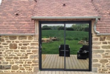 Baie coulissante gris anthracite en aluminium avec un vitrage antelion en argent