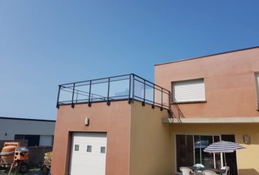Pose d'un garde corps vitré avec main courante, fabriqué sur mesure pour terrasse accessible au dessus d'un garage