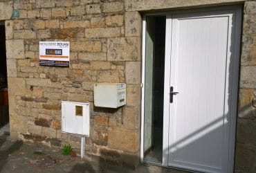 Porte d'entrée PVC Armoise et fenêtre PVC posées sur une maison en pierres par la Mneuiserie Bouan