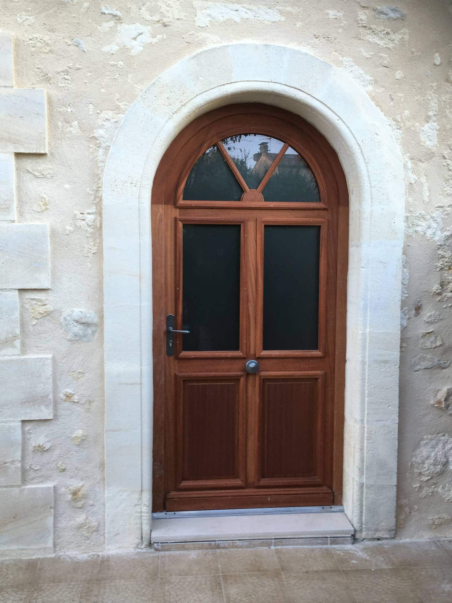 Porte d’entrée bois cintrée avec vitrage installée par AMF sur Villegouge (33)