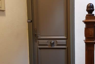 Porte d'entrée bois pleine modèle Fève posée sur un appartement par D'Eco Ouest