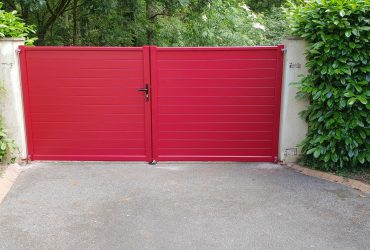 Portail aluminium sur mesure à ouverture battante et manuelle avec 2 vantaux habillés d'un Rouge Feu RAL 3000, le tout fourni et posé par ADECI