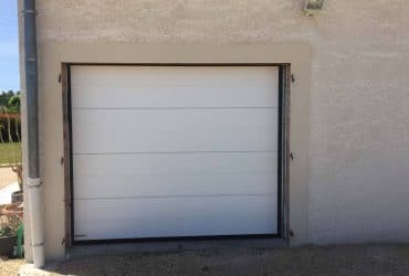 Porte de garage sectionnelle motorisée blanche fournie et posée à Baudrières par SV Réalisations, installateur Solabaie